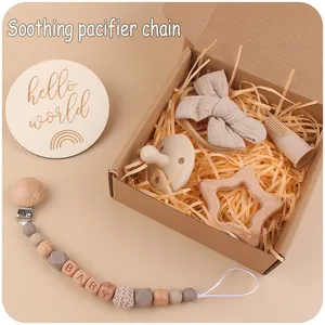 Detail of baby gift set with wooden pacifier chain, star teether, and bow headband