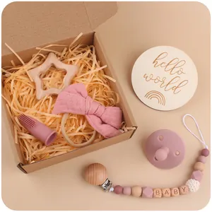 Close-up of baby gift set with star teether, pacifier clip and bow headband in box