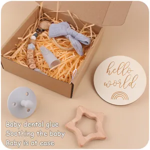 Detail of baby gift set including star wooden teether and blue bow headband in a gift box
