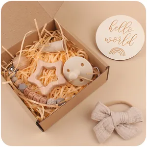 Baby gift set with star wooden teether, silicone pacifier, and bow headband in a gift box