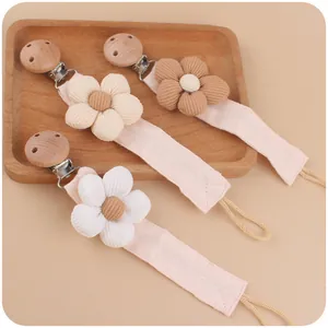 Detailed macro view of 3-pack cotton fabric pacifier clips with corduroy daisy flowers