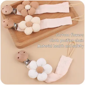 Detailed view of floral cotton linen pacifier clips with beech wood and corduroy flowers