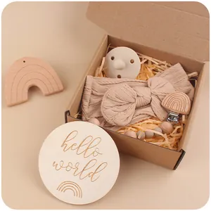 Baby gift set with pink bow headband, pacifier clip, wooden toy and rainbow milestone card