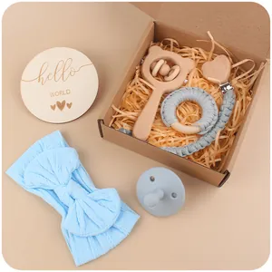 Detalle del set de regalo para bebé con sonajero de madera, chupetero y diadema