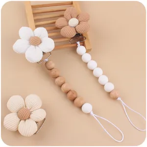 Close-up of corduroy flower pacifier clips with natural wooden and silicone beads