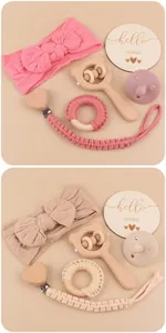 Detalle de los sets de regalo para bebé rosa y beige con mordedor de madera y cinta