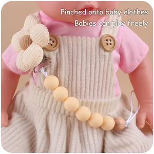 Detail of flower pacifier clip attached to baby clothes with silicone beads