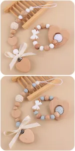 Close-up of handmade pacifier clip and wooden teething ring set for infants