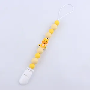 Detail of baby pacifier clip with yellow silicone beads and giraffe charm decoration