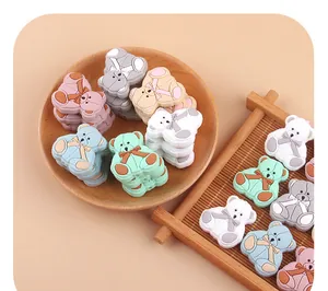 Silicone bear beads for DIY pacifier clips in pastel colors on wooden trays