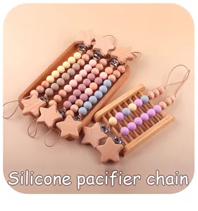 Vue détaillée des attaches-tétines en silicone avec étoiles en bois et perles Morandi