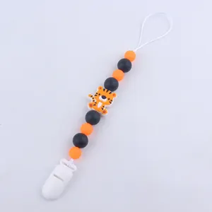 Silicone pacifier clip with orange and black beads and a cute tiger charm on white background