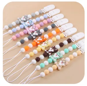 Detail view of colorful cartoon cat silicone pacifier clips in various soft macaron shades