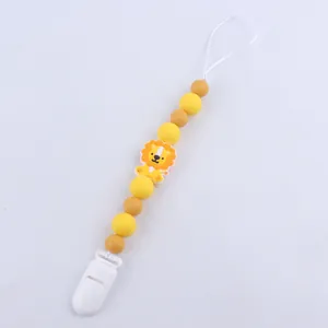 Detail of yellow silicone baby pacifier clip with cartoon lion and beaded chain links