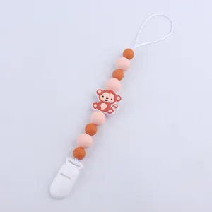 Detail of baby pacifier clip with colorful silicone beads and a cute cartoon monkey