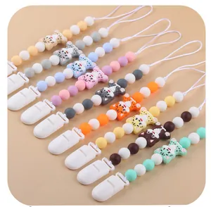 Macro detail of nine colorful silicone baby pacifier clips with cute cat motifs