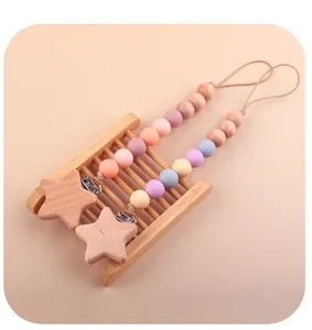 Détail de l'attache en bois de hêtre en étoile et perles de silicone pour chaîne de tétine