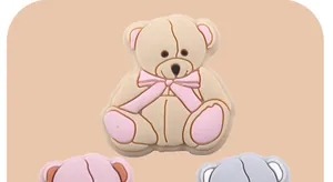 Close-up of a cute cartoon teddy bear charm with a pink bow for DIY pacifier chains