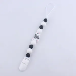 Detail of silicone baby pacifier clip with black and white beads and a zebra charm