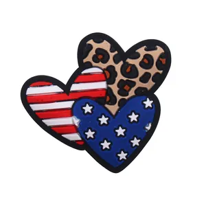 Dettaglio di ciondoli a cuore per scarpe con strisce bandiera USA e motivo leopardato