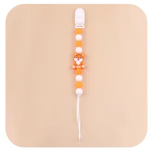 Detail of orange and white silicone bead pacifier clip with cartoon tiger decoration