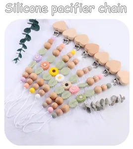 Detailed flat lay of silicone pacifier clips with daisy and heart beech wood beads