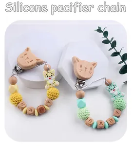 Dettaglio di catenelle portaciuccio con perline in silicone e clip a gatto in legno