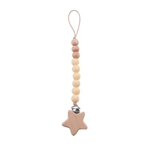 Détail du clip étoile en bois et des perles en silicone sur une attache-tétine neutre