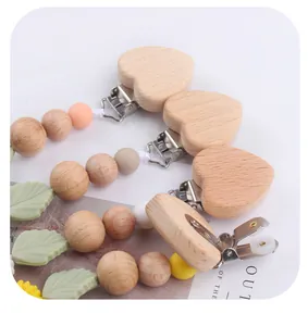 Detail of wooden heart clip and colorful silicone beads on a handmade baby pacifier chain