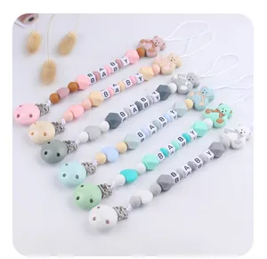 Selection of colorful silicone pacifier clips with bear decor and wooden letter beads