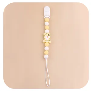 Detail of baby pacifier clip with yellow cartoon tiger and silicone beaded chain