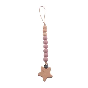 Détail de l'attache-tétine en bois de hêtre avec étoile et perles de silicone rose