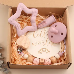 Baby gift set with star teething toy, pacifier clip, and hello world milestone plaque
