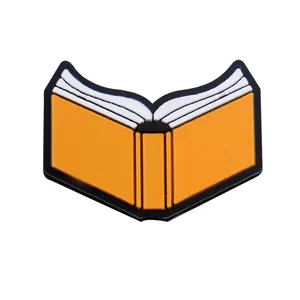 Détail d'une breloque en PVC en forme de livre orange et blanc pour sabots et bracelets