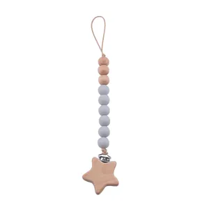 Détail du clip en bois de hêtre en forme d'étoile et perles en silicone sur l'attache-tétine