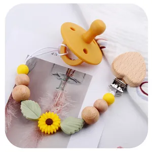 Detailed close-up of a sunflower silicone baby pacifier chain with heart beech wood clip