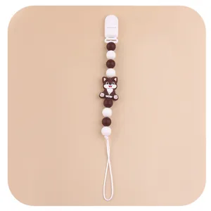 Close-up of brown and white baby pacifier clip with cartoon cat silicone beads