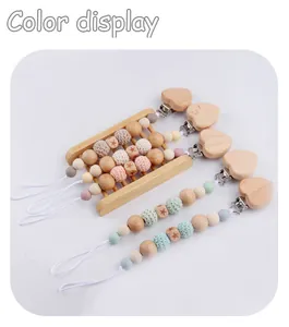 Detail view of colorful silicone and beech wood baby pacifier clips in various designs