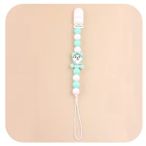 Detail of baby pacifier clip with mint green silicone beads and cartoon cat figure