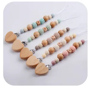 Detail of DIY beechwood heart pacifier clips with colorful silicone beads and crochet textures