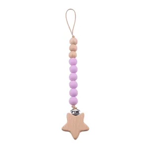 Détail d'attache-tétine avec clip en bois étoile et perles en silicone mauves