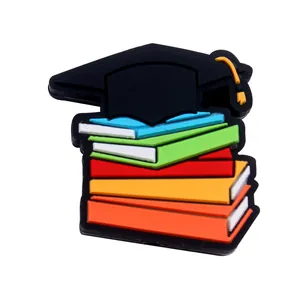 Gros plan d'une breloque chapeau de diplôme sur livres colorés pour attache-tétines