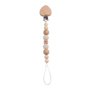 Detail of wooden heart clip with crocheted beads and star engraved block on pacifier chain