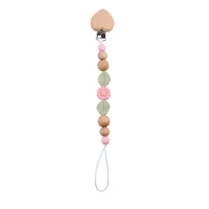 Detail of baby pacifier clip with beech wood heart, daisy beads and silicone chain