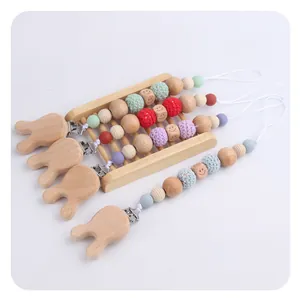 Detailed view of handmade wooden baby pacifier clips with crochet beads and bunny face