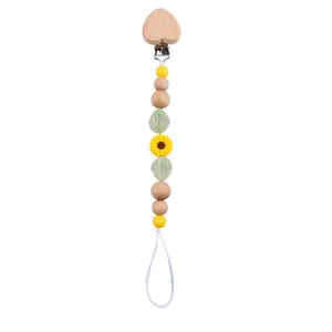 Detail of baby pacifier clip with beech wood heart and yellow sunflower silicone beads