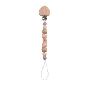Detail of wooden heart clip and pink silicone beads on a handmade baby pacifier chain