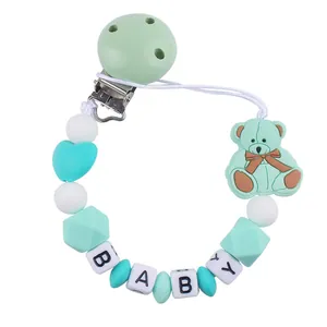 Detail of baby pacifier clip with mint green silicone bear and BABY letter beads
