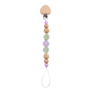 Close-up of heart-shaped beech wood clip and purple daisy silicone beads pacifier chain
