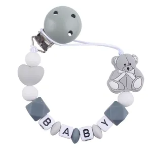Detail of silicone pacifier clip with baby letter beads and grey cartoon bear charm